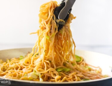 Chow mein noodles being served from a skillet