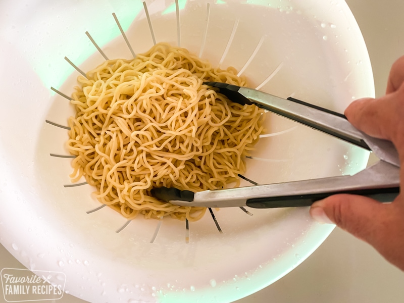 Chow mein noodles being rinsed