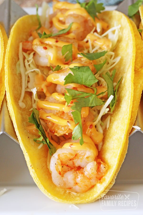 This Spicy Shrimp Taco Recipe makes the best meal or snack. Tender bite-size shrimp, crunchy cabbage and spicy sauce comes together in just minutes and disappears even faster! Close up of a shrimp taco.