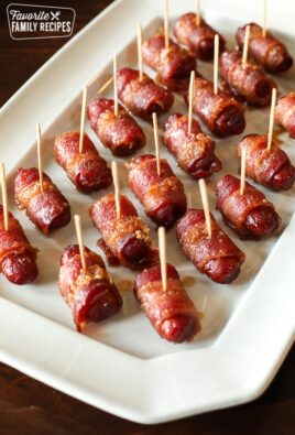 Bacon Wrapped Lil Smokies Appetizer with toothpicks in each one served on a white tray.