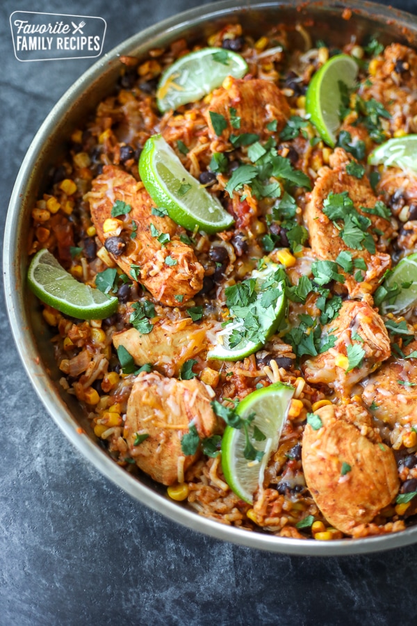 Spanish chicken and rice skillet in a skillet with lime garnished on top. 