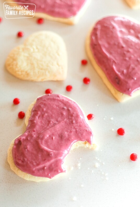 Sugar Cookies with Raspberry Frosting with a bite out of one cookie