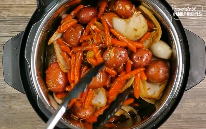 Instant pot with roast, potatoes, carrots, and seasonings.