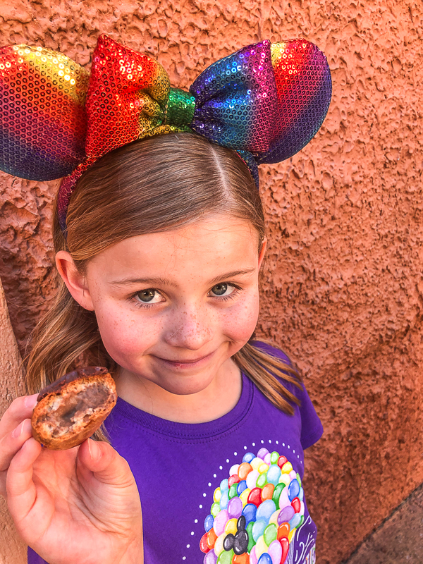 A you girl with Minnie Mouse ears holding a chocolate cream parfait from the Les Halles Boulangerie-Patisserie at Epcot Walt Disney World