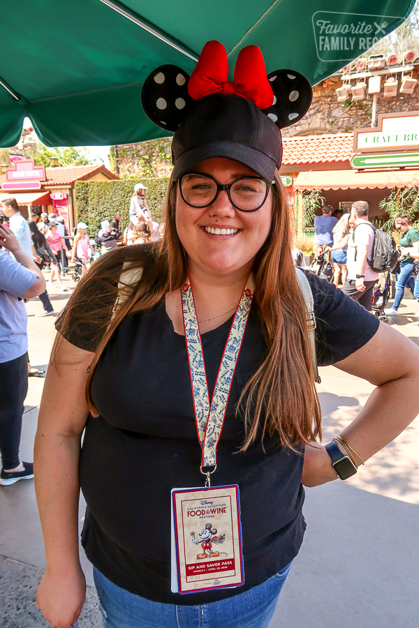 Girl wearing a Disney California Adventure Food and Wine Festival Sip and Savor Pass on a Lanyard