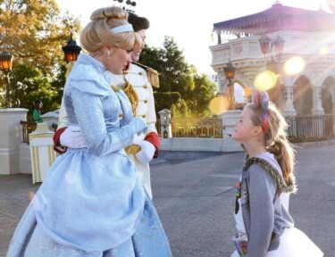 A young girl looking up to Cinderella and Prince Charming at Walt Disney World