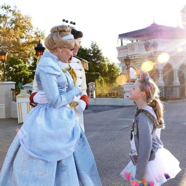 A young girl looking up to Cinderella and Prince Charming at Walt Disney World