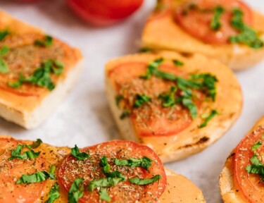 Slices of Cheesy Italian Bread with fresh tomatoes on the side