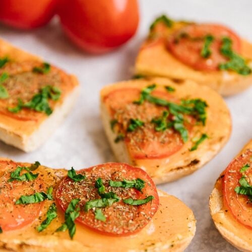 Slices of Cheesy Italian Bread with fresh tomatoes on the side