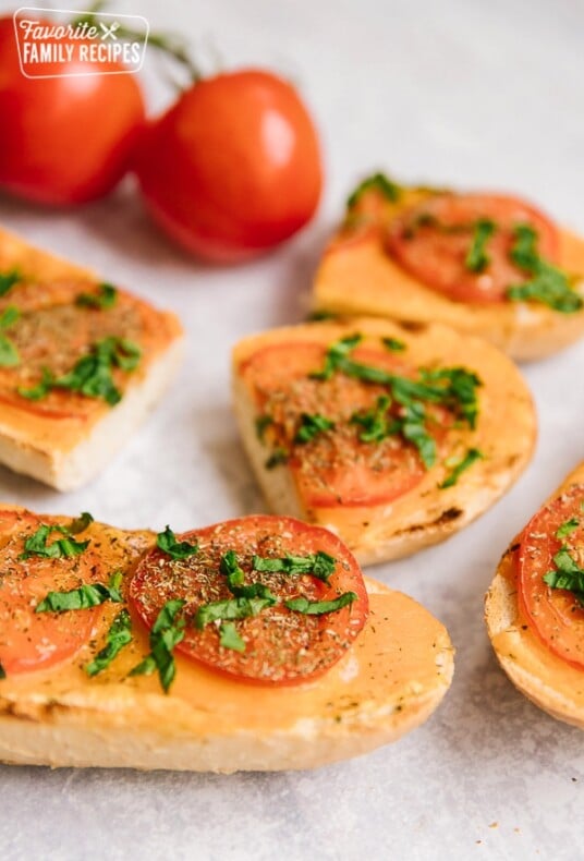 Slices of Cheesy Italian Bread with fresh tomatoes on the side