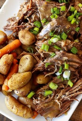 Instant Pot Sunday Beef Roast shredded on a serving plate with potatoes and carrots