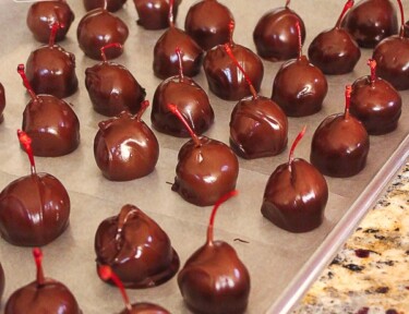 A baking sheet filled with chocolate covered cherries