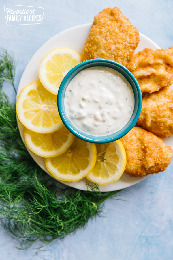 Tartar Sauce on a tray with lemon wedges and fried fish