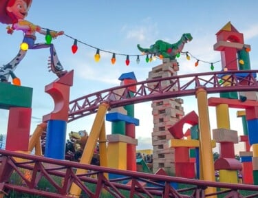 Slinky Dog Dash Roller Coaster with Jessie and Rex holding lights above the coaster