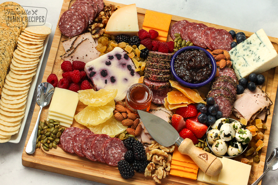 Charcuterie board filled with cheese, meat, and fruits. 