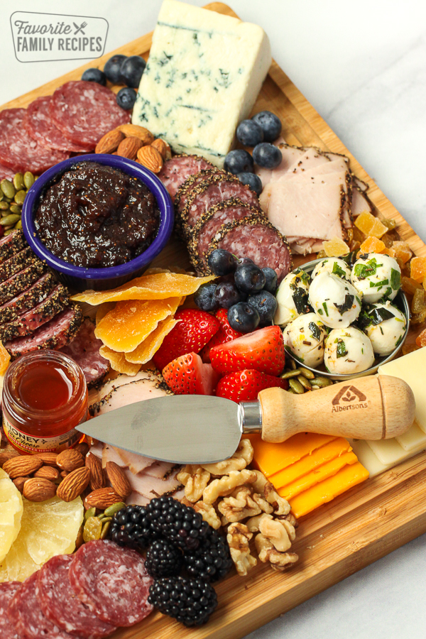 A charcuterie board with cheese, fruit, and meat on it. 