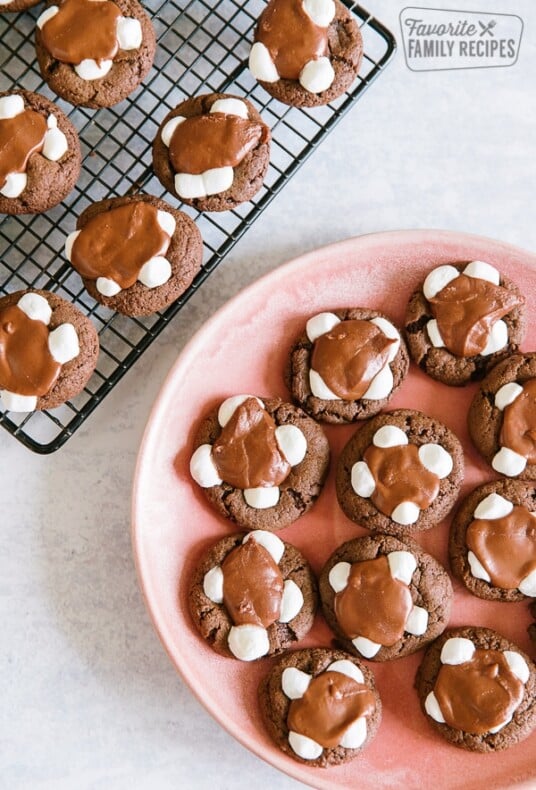 Chocolate marshmallow cookies on a cooling rack with a plate of cookies to the side