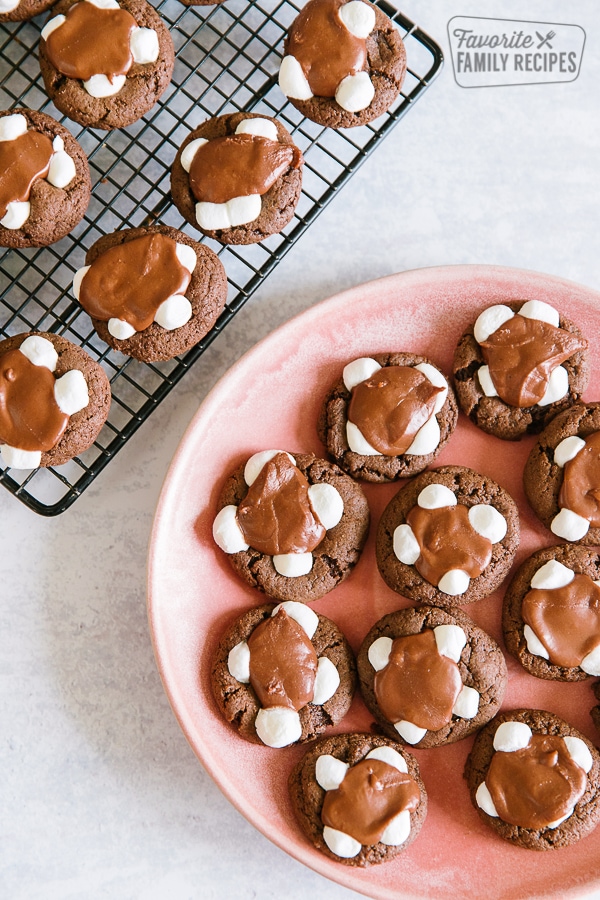 Chocolate marshmallow cookies on a cooling rack with a plate of cookies to the side