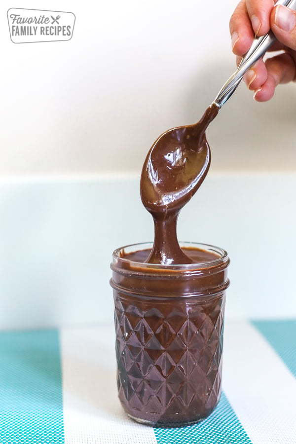 Thick, rich, hot fudge sauce in a glass jar.