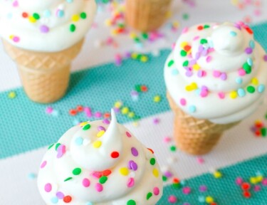 Four Ice Cream Cone Cupcakes on a teal and white striped tablecloth