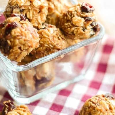 PB & J Energy Bites in a glass square bowl on a checkered table cloth.