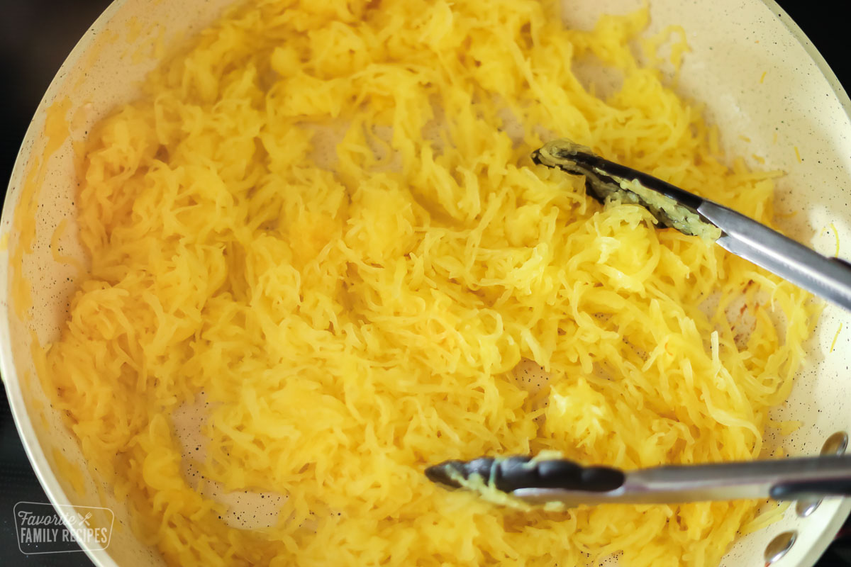 Shreds of spaghetti squash in a large skillet with butter