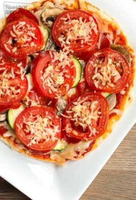 A healthy 350 calorie pizza with mushrooms, zucchini, and tomatoes