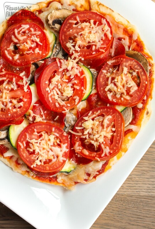 A healthy 350 calorie pizza with mushrooms, zucchini, and tomatoes