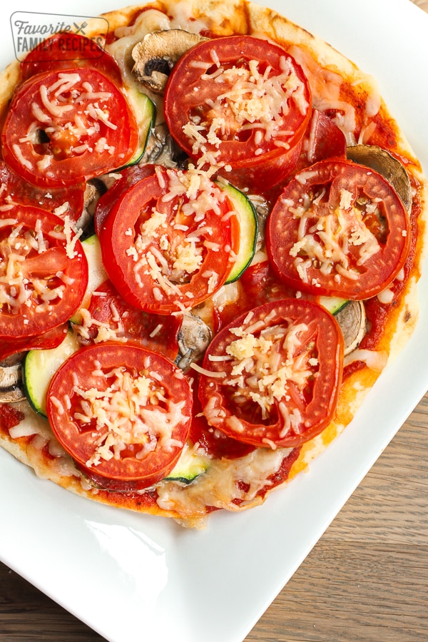 A healthy 350 calorie pizza with mushrooms, zucchini, and tomatoes