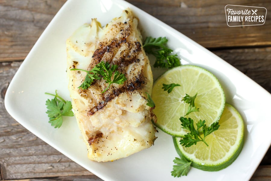 Cilantro Lime Grilled Halibut on a plate with lime slices and cilantro garnish on a plate