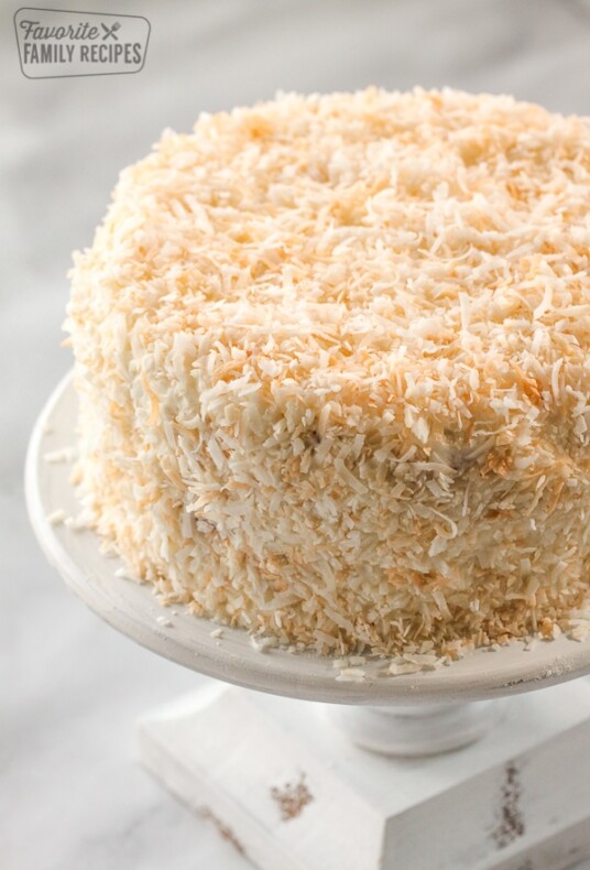 A round coconut cream cake on a cake platter