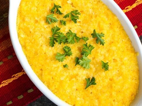 A casserole dish of Sweet Corn Cake (Tamalitos) on a brightly colored placemat