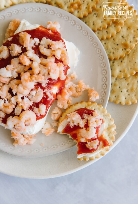 Cream Cheese Shrimp Dip on a cracker with a bite taken out of it