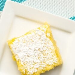 A square white plate with a lemon bar on it