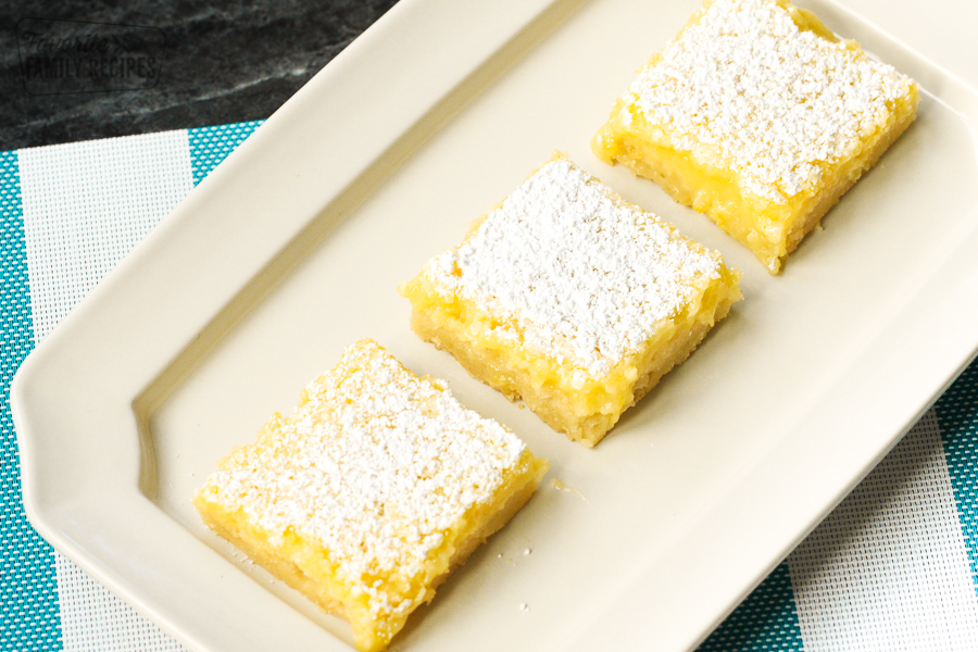 A white tray with three lemon bars in a row