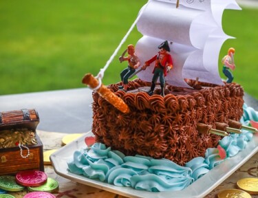 Pirate ship birthday cake on a treasure map.