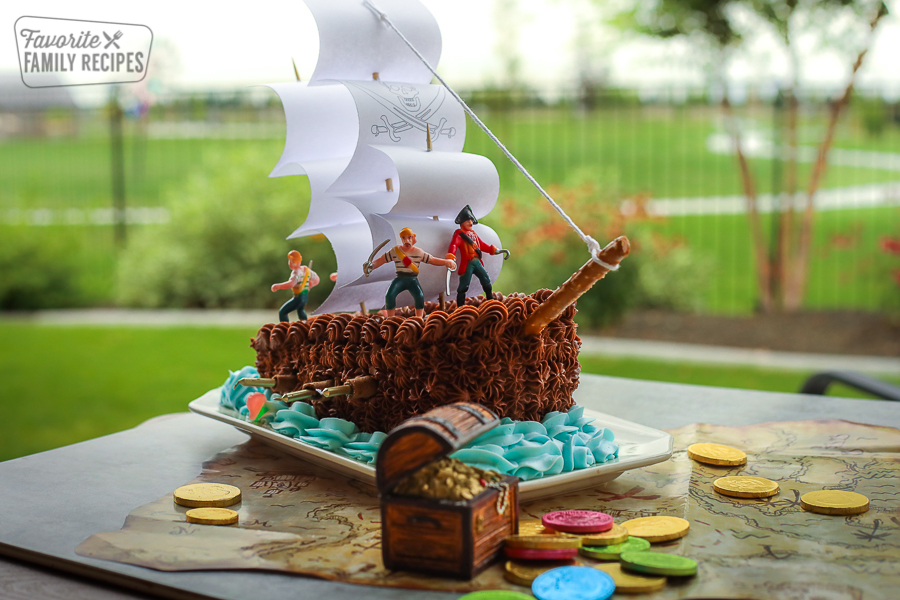 Pirate Ship Birthday cake on a pirate map surrounded by gold coins.