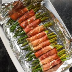 Prosciutto Wrapped Asparagus on a white serving platter