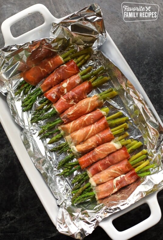 Prosciutto Wrapped Asparagus on a white serving platter