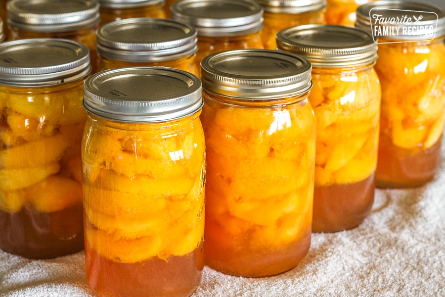 Several glass bottles filled with peaches that have been canned at home