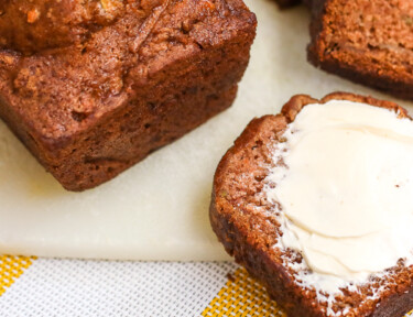 A slice of gluten free zucchini bread on a cutting board