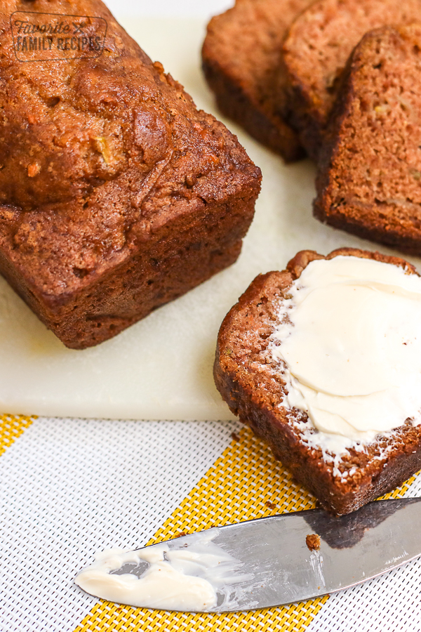 A slice of gluten free zucchini bread on a cutting board.