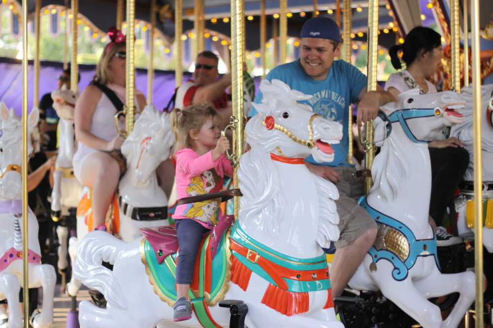 Jared and Gracie riding the carousel in Fantasyland Disneyland.