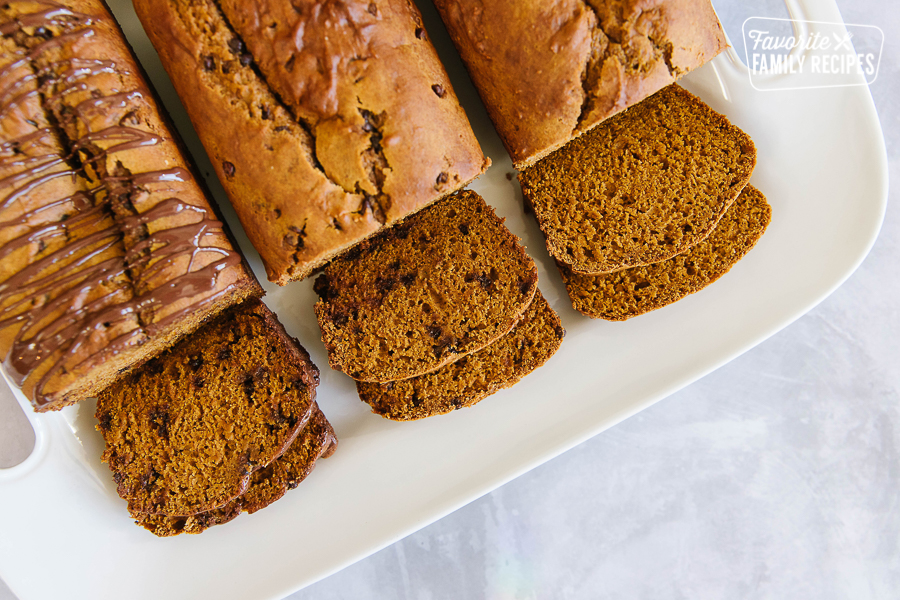 Three loaves of pumpkin bread on a white platter