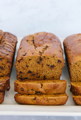 3 loaves of pumpkin bread with two cut slices off of each loaf.