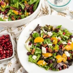 Christmas Salad in a white bowl with a bowl of pomegranate seeds