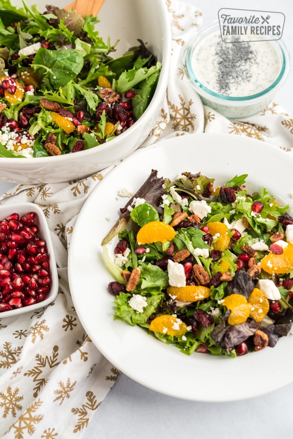 Christmas Salad in a white bowl with a bowl of pomegranate seeds