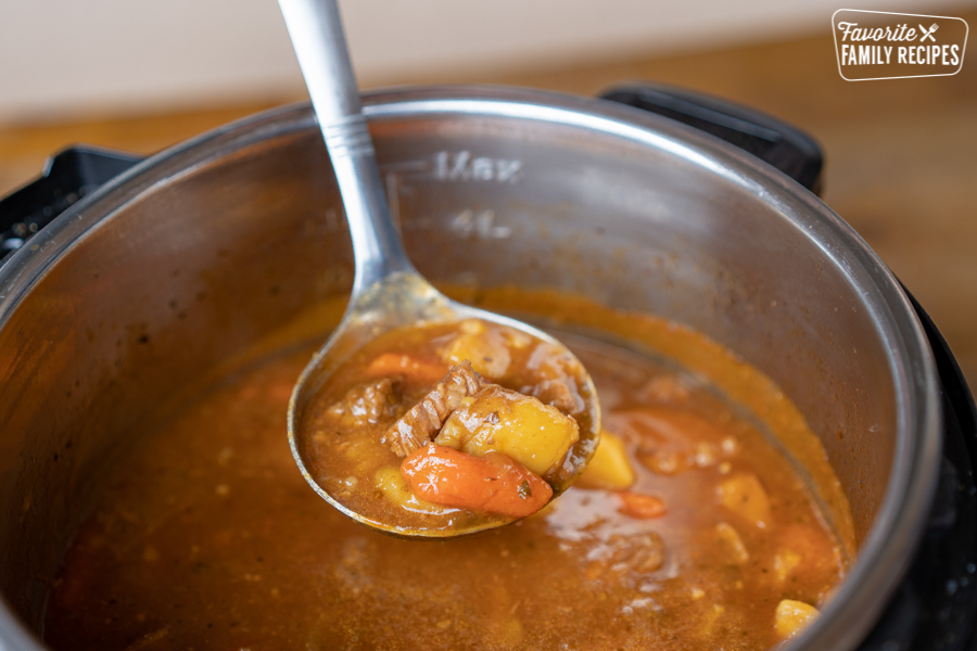 Instant pot beef stew being ladled out of an instant pot