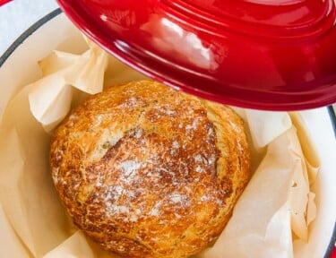 Close up view of a loaf of Dutch oven bread in parchment paper