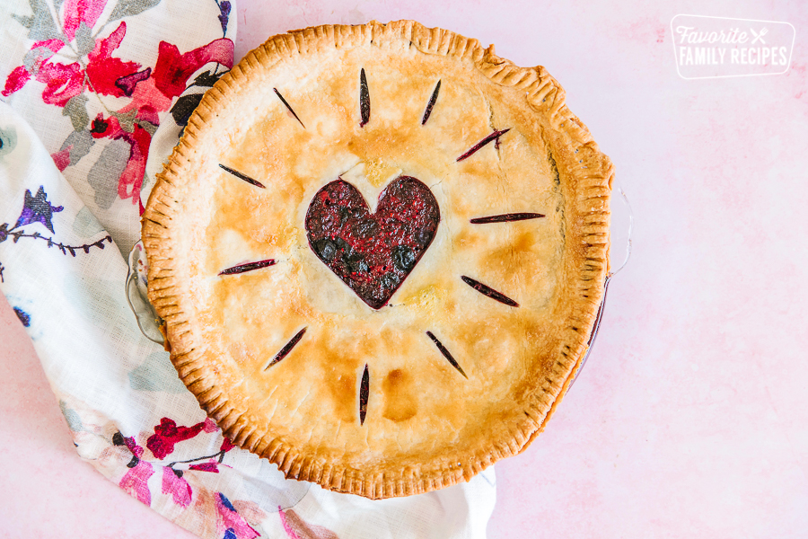 Top view of a berry pie with a heart cut in the center of the crust.